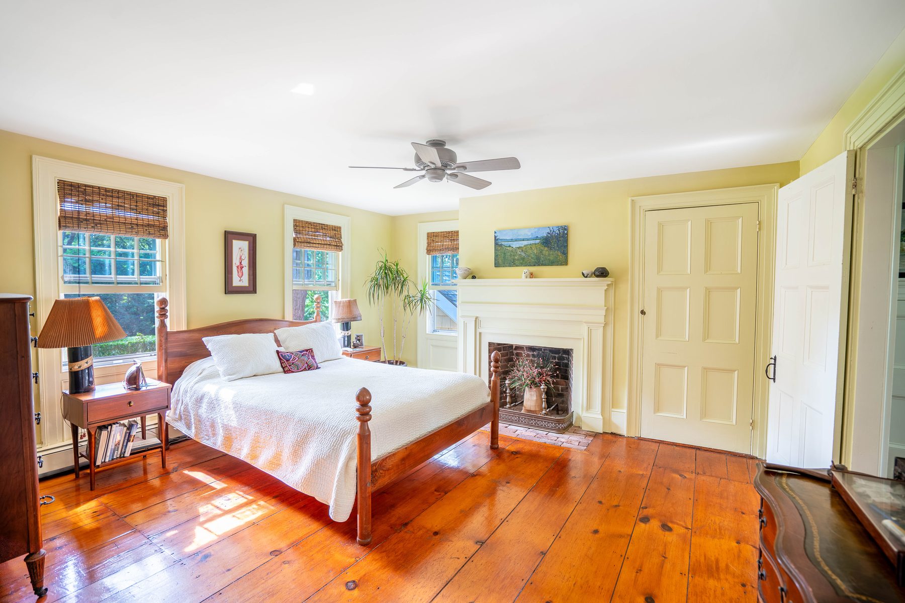 Primary bedroom with original fireplace and wide-plank floors