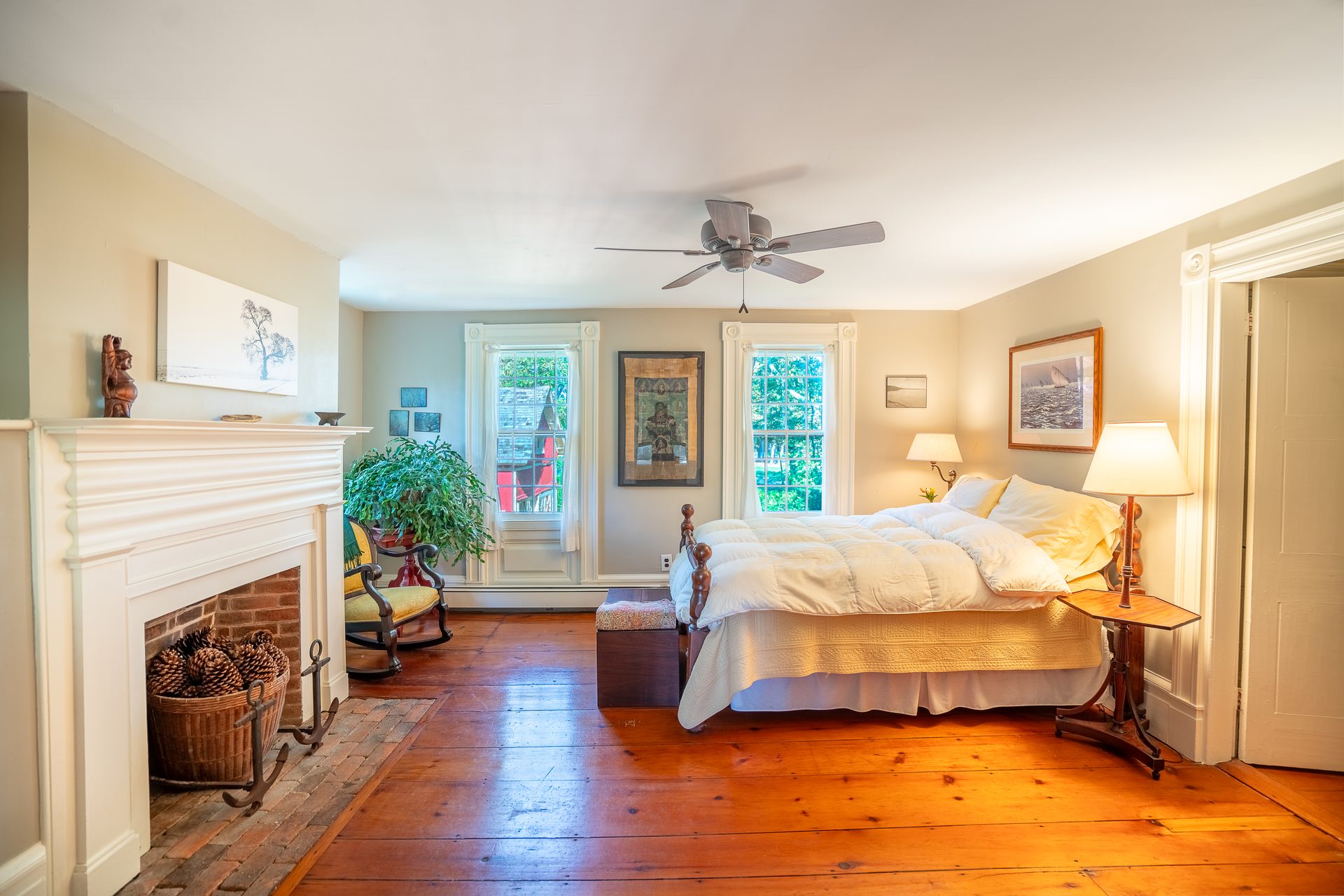 Primary bedroom with white mantel and basket of pinecones