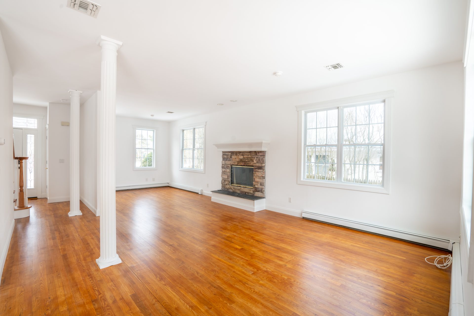 Yellow living room with white mantel and pine floors