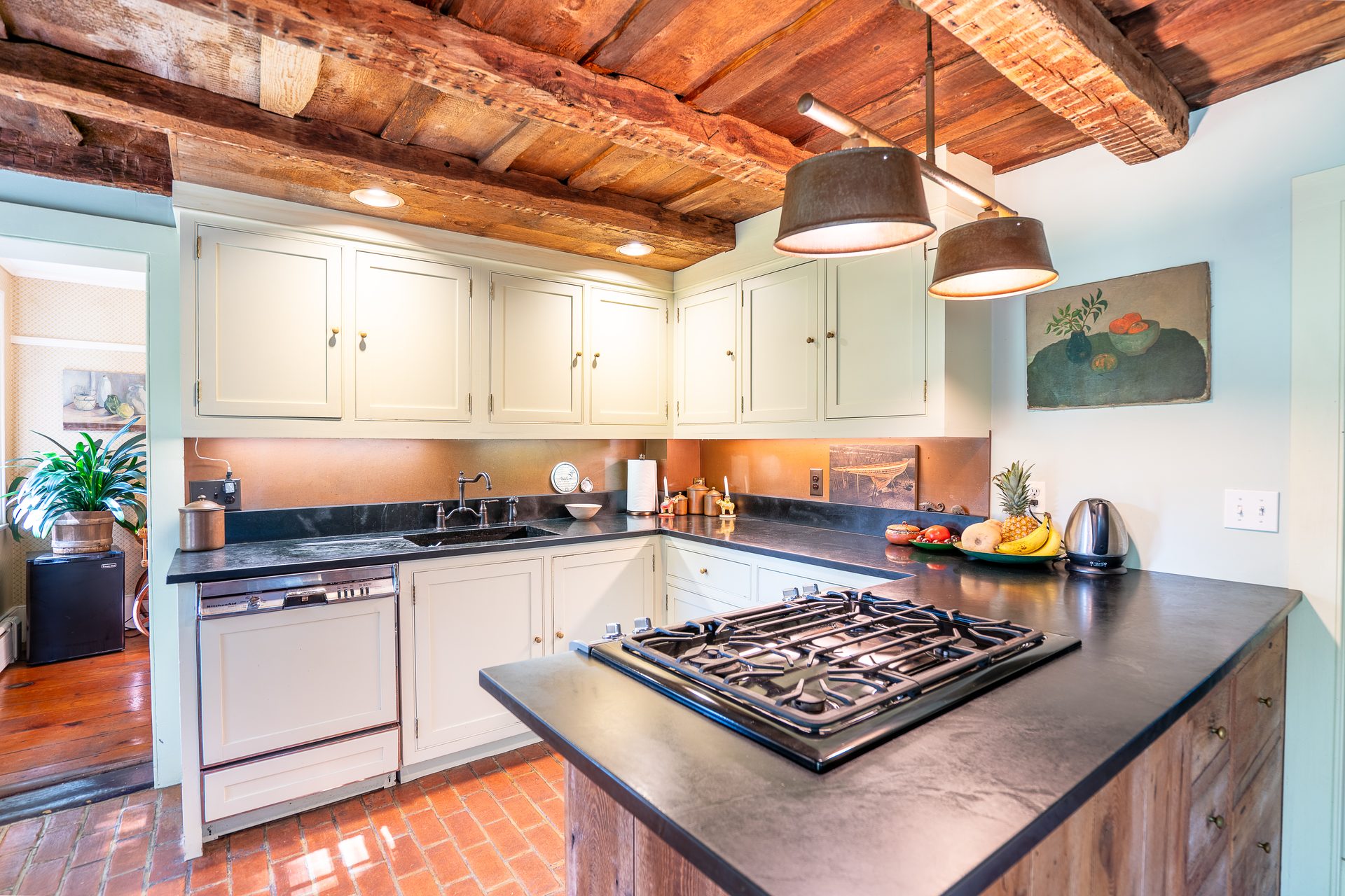 Kitchen with hand-hewn beams and brick floor