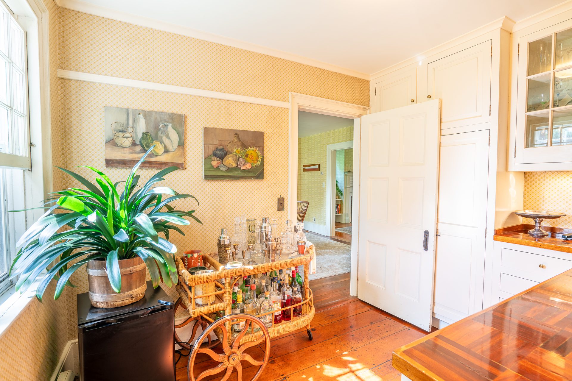 Yellow parlor with period wallpaper and fireplace